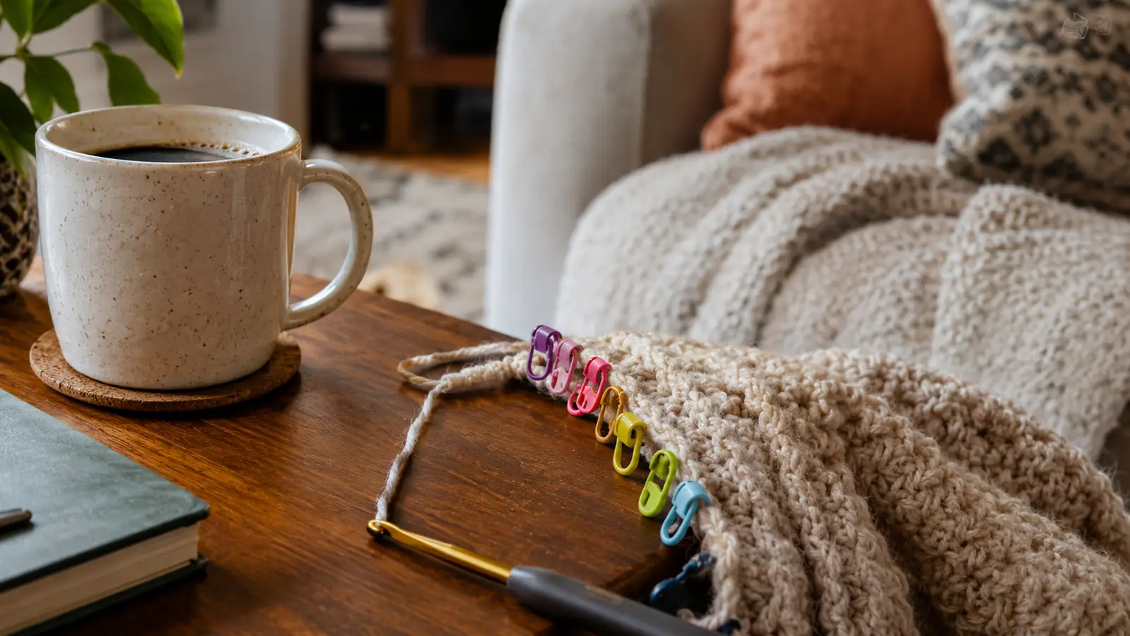 A row of small locking stitch markers in assorted colors clipped along the edge of a crochet project
